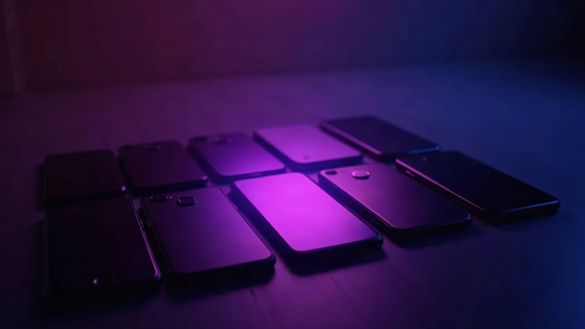Diversi smartphone allineati, un faretto viola su quello centrale (illustrazione dell’articolo)